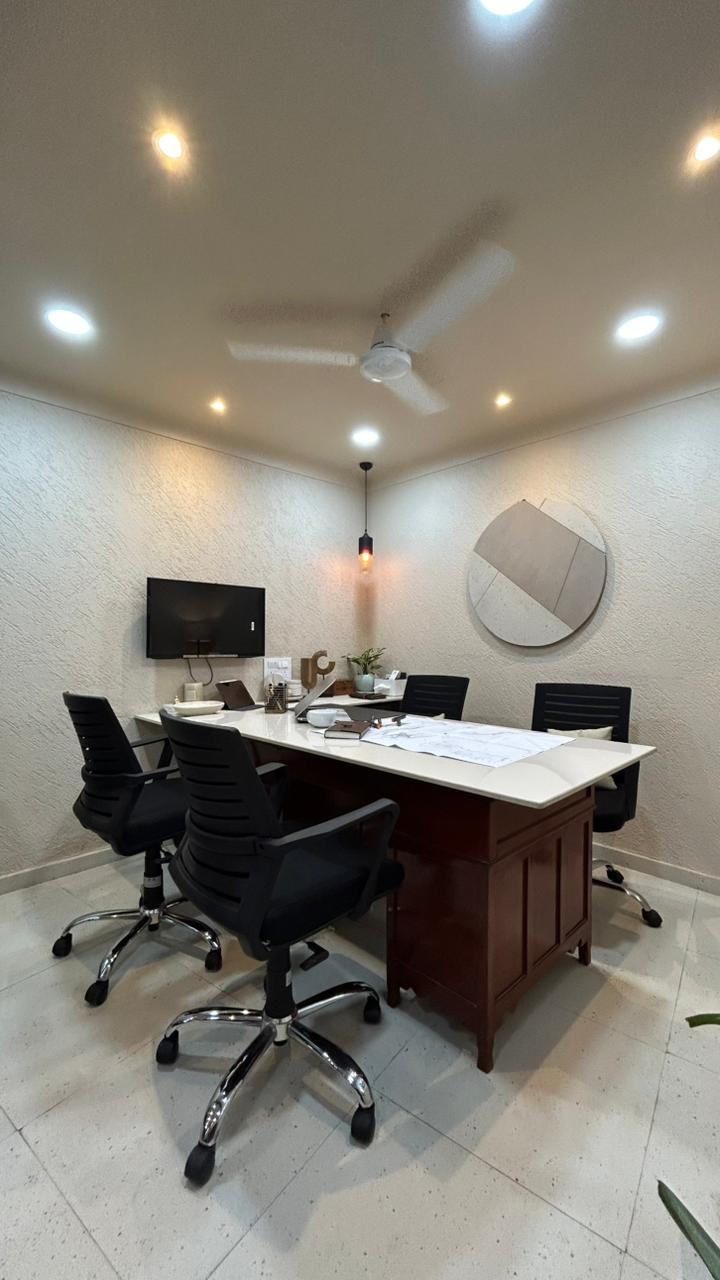 Architects discussing project brief with drawings and laptop